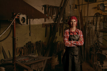 Female blacksmith in workshop standing confident portrait