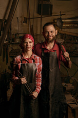 blacksmiths couple with tools in smithy portrait