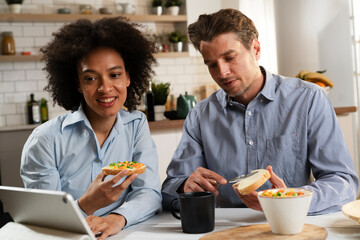 Loving couple drinking coffee and eating sandwich. Happy smiling wife enjoy in the morning with her husband..