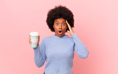 afro woman looking happy, astonished and surprised, smiling and realizing amazing and incredible...