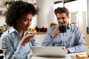 Loving couple drinking coffee and eating sandwich. Happy smiling wife enjoy in the morning with her husband..