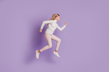 Fototapeta na wymiar Profile photo of positive sportive lady jump run wear white jumper posing on purple background