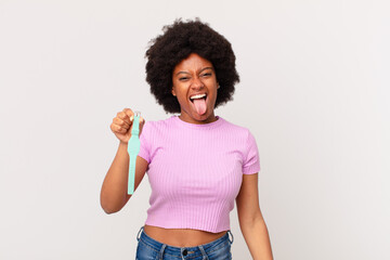 afro woman with cheerful, carefree, rebellious attitude, joking and sticking tongue out, having fun...