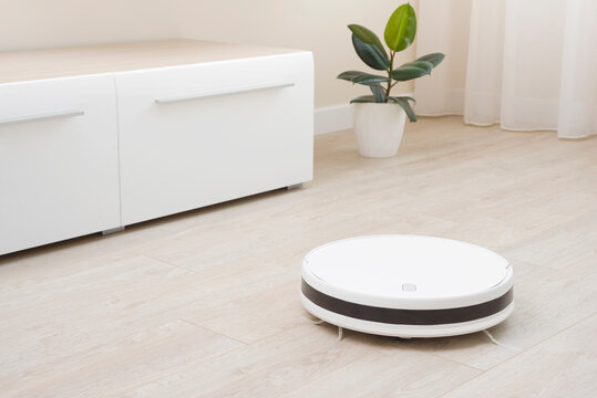 Robot vacuum cleaner automatic cleaning of laminate floor in house - Powered by Adobe