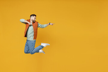 Full length side view young smiling happy fun caucasian man 20s wear orange vest mint sweatshirt...