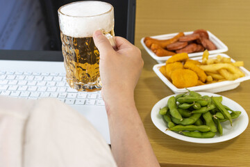 家で、ノートパソコンを使い、オンライン飲み会する女性イメージ