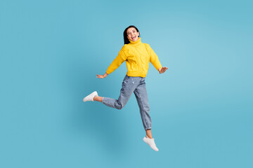 Fototapeta na wymiar Full length body size side photo of brunette jumping high laughing overjoyed isolated on vibrant blue color background