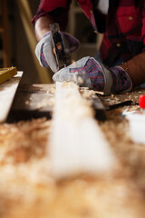 Close up of carpenter working in workshop. Carpenter working on wood craft at workshop.