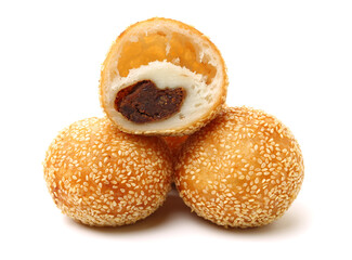 Golden fried dessert balls covered with sesame on white background