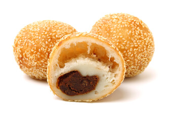 Golden fried dessert balls covered with sesame on white background