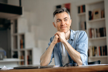 Portrait of happy handsome mature gray-haired caucasian freelancer or manager, stylishly dressed,...