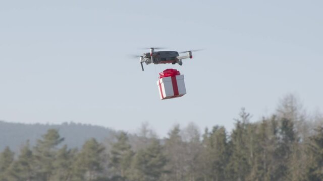 small drone flying cross country carrying giftbox to its destination