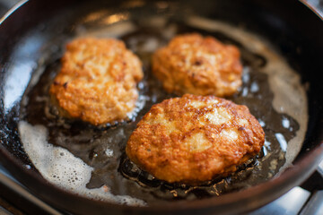 Fried chicken burgers in a pan.