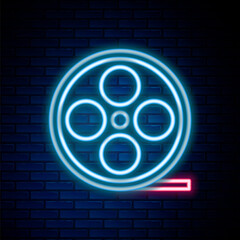 Glowing neon line Film reel icon isolated on brick wall background. Colorful outline concept. Vector