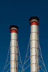 Two tall tubes against the blue sky.