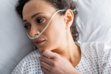 overhead view of sick african american woman lying in hospital bed with nasal cannula