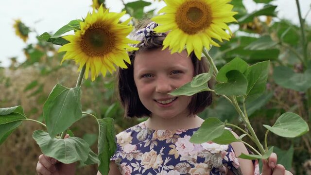 pretty girl closes her eyes with sunflowers