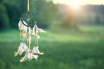 magic dream catcher on summer landscape, gentle green natural background. ethnic ritual, Shaman native amulet. hygge, lagom, relax concept. copy space - obrazy, fototapety, plakaty