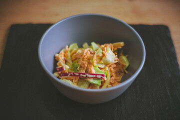 Bowl of coleslaw on grey slate