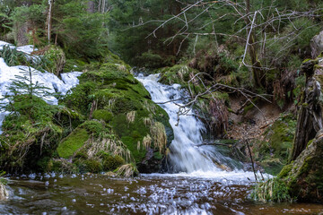 Fototapeta premium Cascade falls over mossy rocks