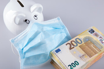 Money pig on face mask on the background of banknotes. 