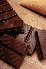 Chunks of dark and milk chocolate on a wooden table