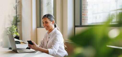 Businesswoman in office using phone