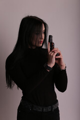 Young brunette woman holding a gun in her hands