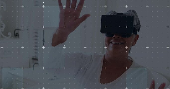 White Particles Moving Over Grid Network Against African American Senior Woman Wearing Vr Headset