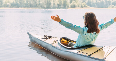 A woman enjoys kayaking on the river. Feeling of freedom from the bustle of the city.