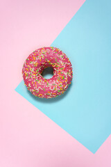 Creative food diet concept photo of donut bite on pink blue background.