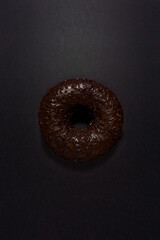 Creative food diet concept photo of donut bite on black background.