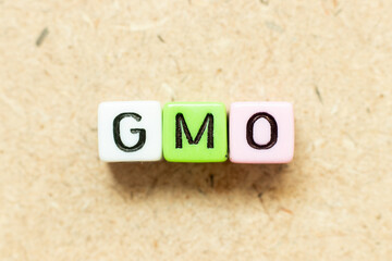 Color alphabet letter block in word GMO (abbreviation of Genetically Modified Organisms) on wood background