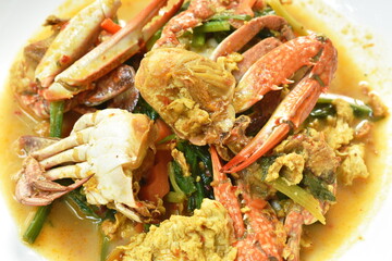 stir fried swimmer crab in yellow curry and egg on plate