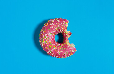 Creative food diet concept photo of donut bite on blue  background.