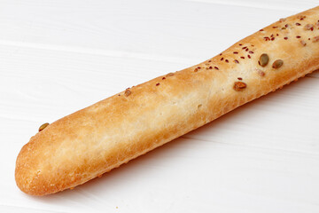 Fresh baguette bread on white wooden table