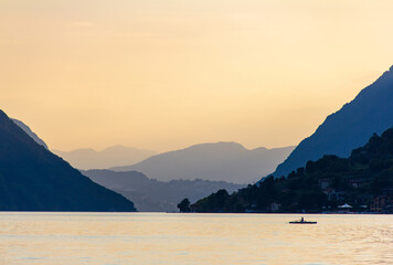 Sunset over lake Lugano between mountains during summer in Porleza, Italy