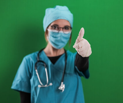 Young female doctor makes a thumbs-up gesture - studio photography