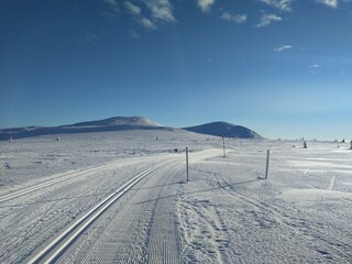 ski track in the mountains with sun and blue sky