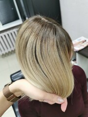 Fototapeta premium Girl with blond hair in a beauty salon. Air-touch. Embossed hair coloring.