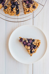 Homemade oatmeal scones with berries on white plate. Vegan sweet baked food. Gluten free pastry.