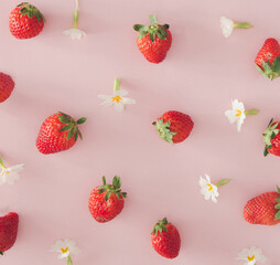 Spring and summer background. White flowers and stawberries on pastel pink backgound.