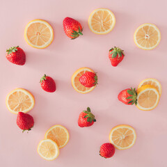 Delicate flat lay background. Lemon and strawberries on  pastel pink background.