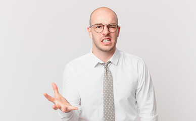 bald businessman looking angry, annoyed and frustrated screaming wtf or what’s wrong with you