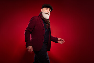 Photo portrait of elder man walking on meeting in vintage clothes isolated bright red color background