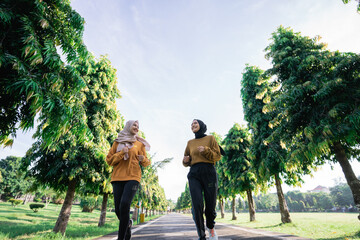 two happy Muslim teenage girls doing outdoor sports together just before breaking the fast in the park © Odua Images