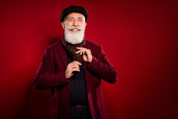 Photo portrait of elder man wearing scarf blazer cap smiling cheerful isolated vivid red color background