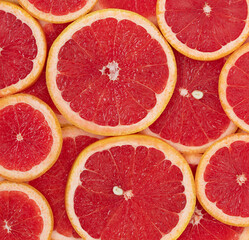 The natural background of red ripe round slices of grapefruit
