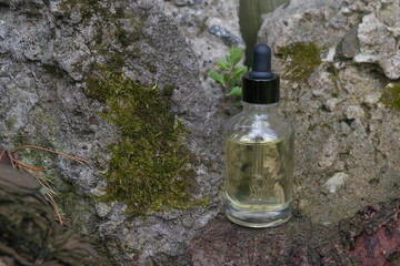 Glass dropper bottle on a natural stone background