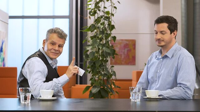 Businessman receiving a business card,trying to feed it to a llama.